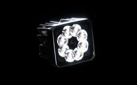 Hella – close-up of an LED headlight with a round reflector grid, glowing against a black background