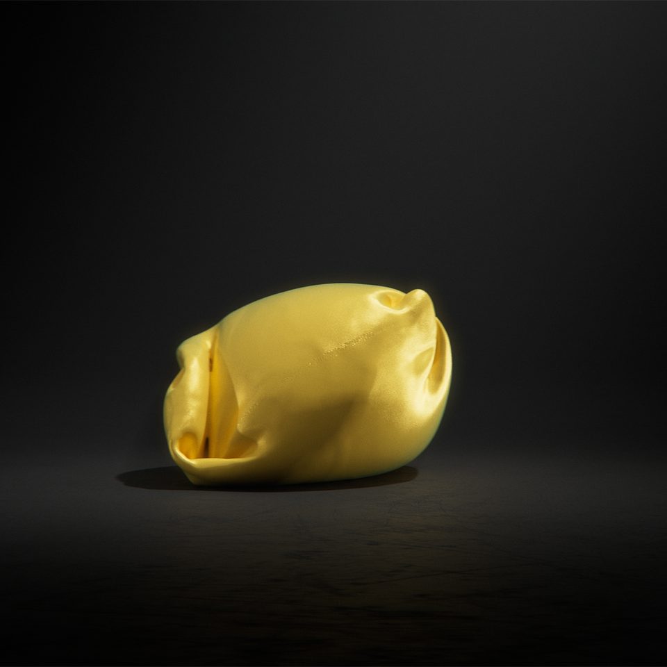folded, golden-yellow object form reminiscent of an upholstered piece of seating furniture, against a dark background