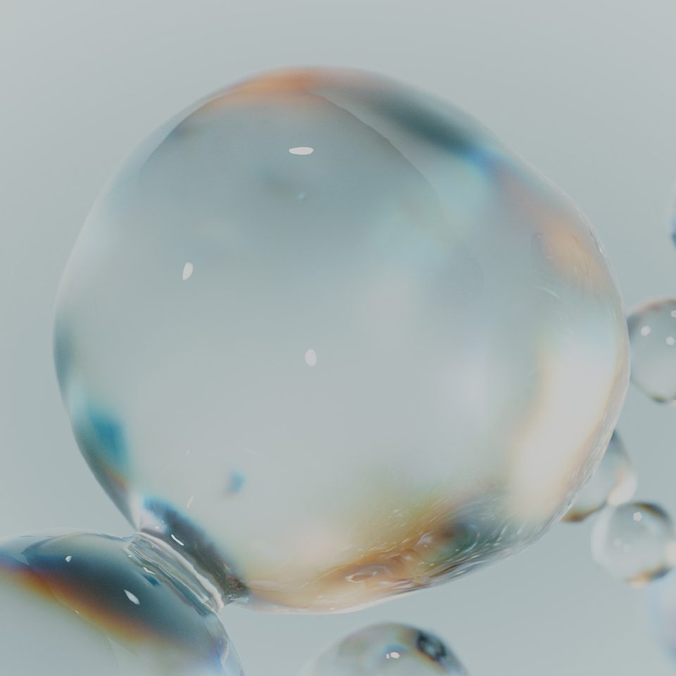 close-up of several transparent, reflective bubbles against a light grey background