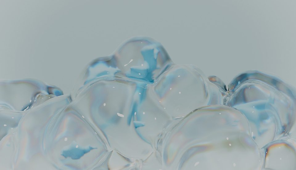 close-up of a large, transparent bubble with iridescent edges against a light grey background