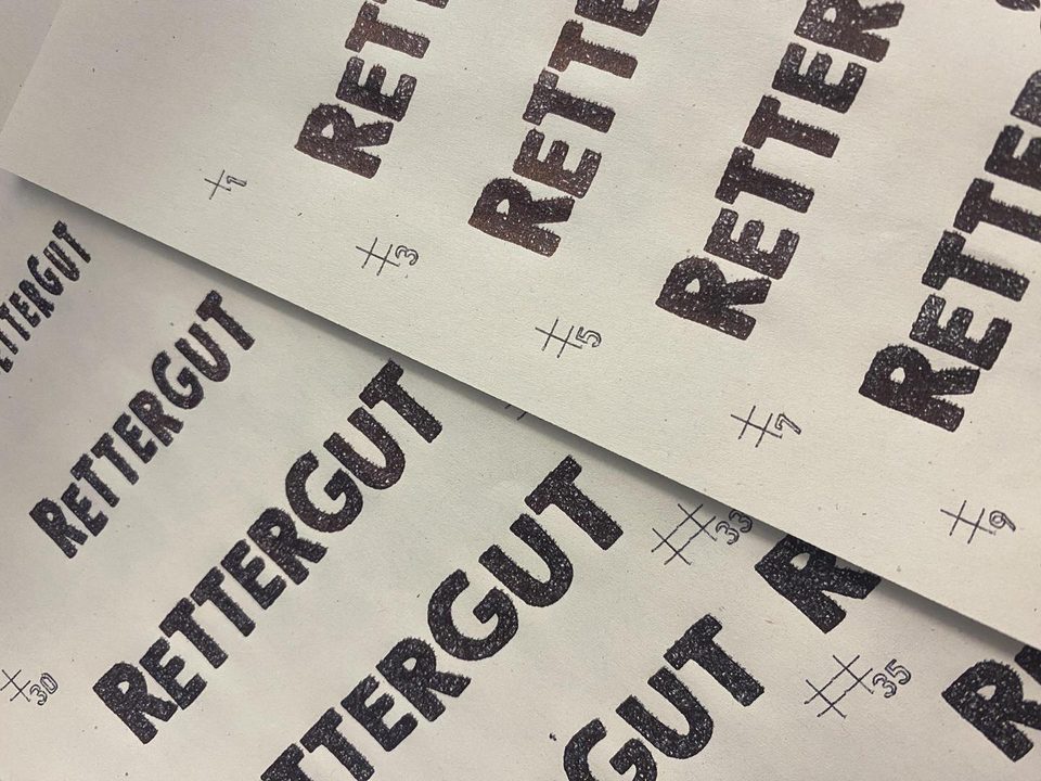 pen-plotter test prints of the Rettergut lettering, hand-drawn on paper